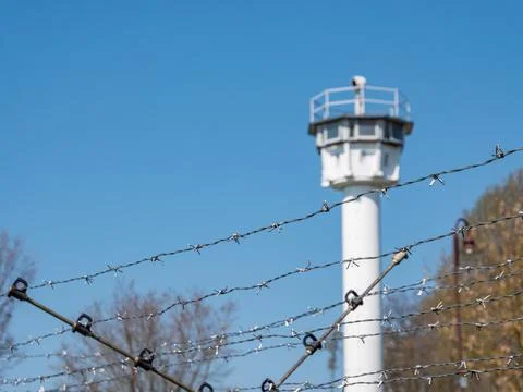 Barbed wire with watchtower former border Stock Photos