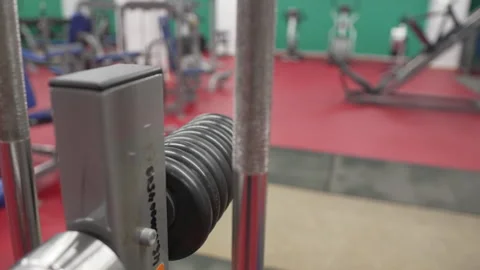 Barbell loaded with weight plates rests in cozy gym space Видео 326444953