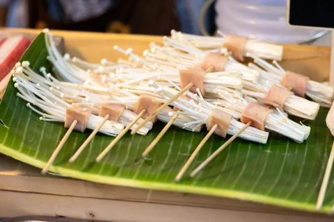Barbeque spit of Enoki mushrooms and pork bacon in Thailand Stock Photos