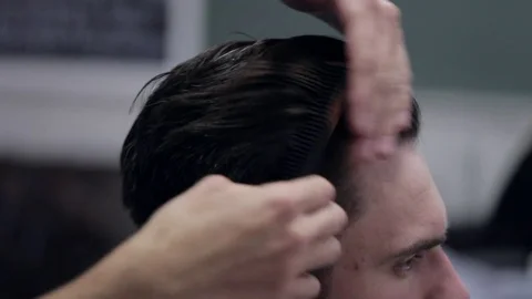 Barber adding some wax and combing client. Stock Footage 69919040
