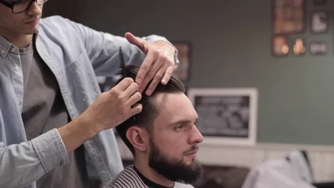 Barber adding some wax and combing client. Stock Footage 70027525