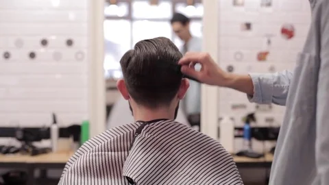 Barber adding some wax and combing client. Stock Footage 70027618