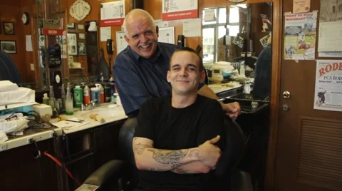Barber and client pose happy to camera in old fashion barber shop Stock Footage 45523686