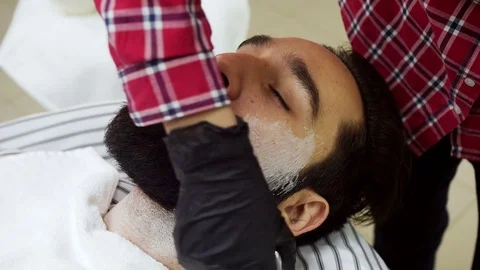 Barber applied to the face shaving foam by a swab Stock Footage 70679492