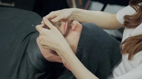 Barber Applying Lotion to Clients Beard Stock Footage 345586045