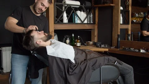 Barber applying shaving foam on beard of client Stock-Footage 127178101