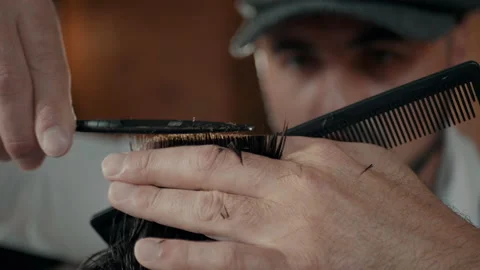 Barber with a beard and a cap. Barber makes a haircut with scissors. Stock Footage 132283070
