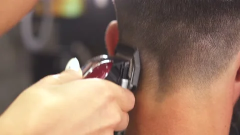 Barber with comb and clipper doing his work. Frame. Close up shot of man getting Stock Footage 159879880
