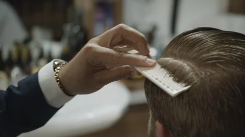 Barber combing and trimming a man's hair in a barber shop 스톡 동영상 117701065