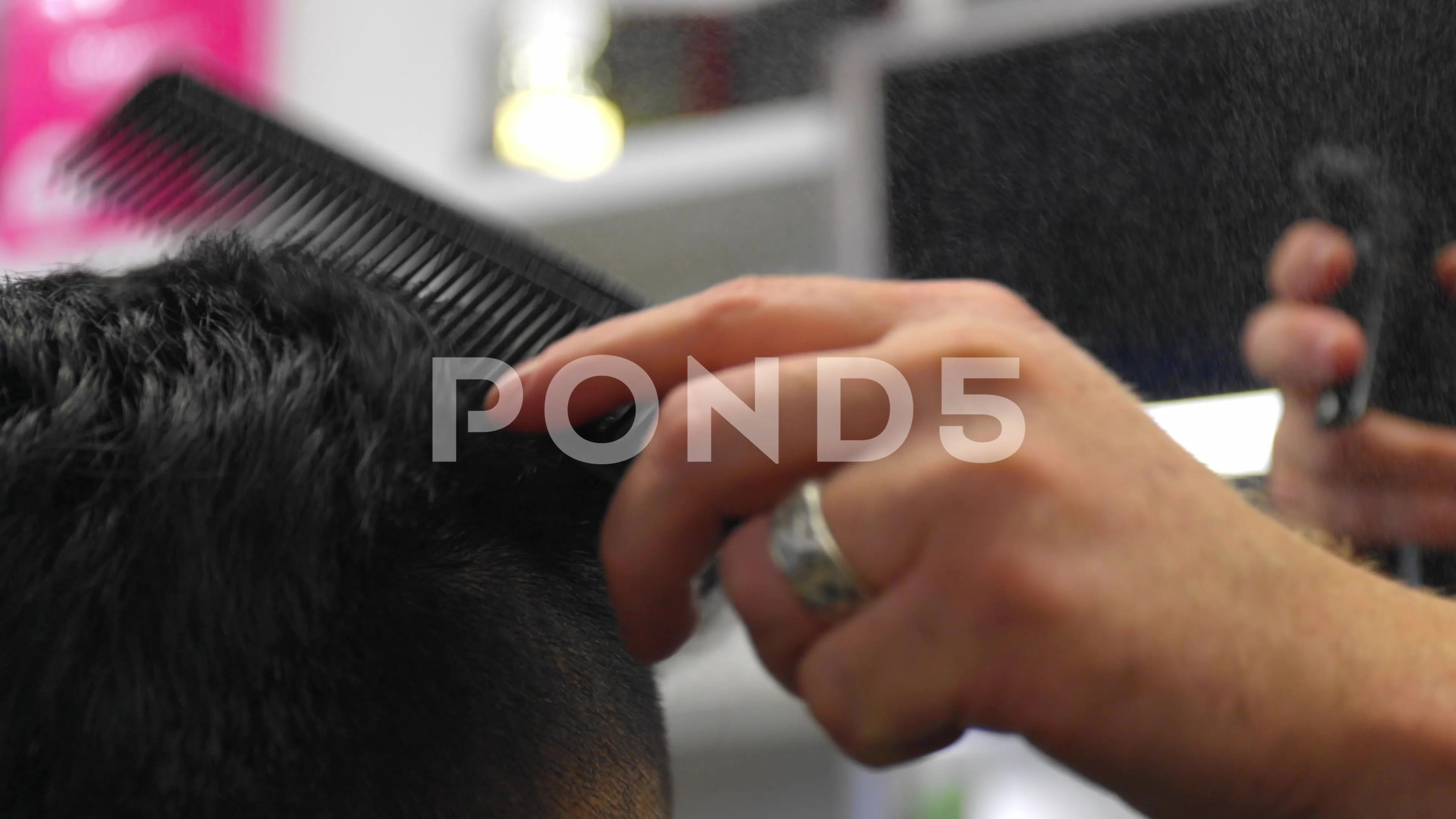 Barber sprinkles hair on the spray gun and combs his hair to a
