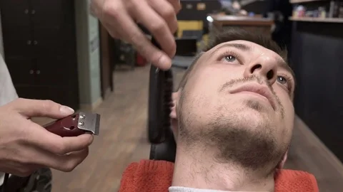Barber combs and cuts the sideburns of the client close-up 4k. Stock Footage 81544240