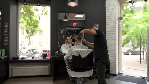 Barber combs the client during haircuts and turns in an armchair that would look Stock Footage