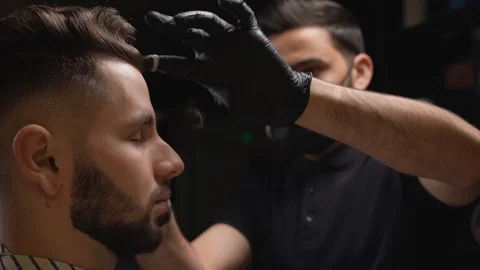 Barber correcting shape of client's eyebrows with thread Stock Footage 123012102