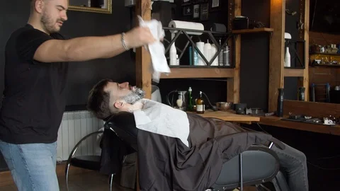 Barber covering face of client with towel Stock Footage 127182213