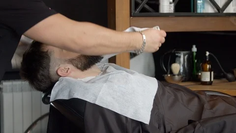 Barber covering face of client with towel Stock Footage 127183015