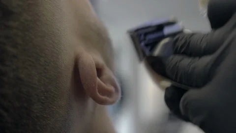 The Barber cuts the beard of a customer at the Barber shop Stock Footage 107984205