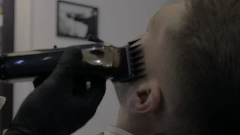The Barber cuts the beard of a customer at the Barber shop Stock Footage 107984638