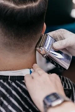 The barber cuts the client with a clipper in his hand, the hairdresser creat Foto stock