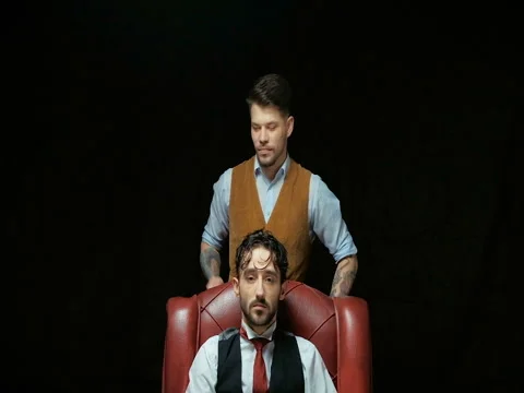 Barber cuts client with scissors hair. On a black background Stock Footage 71695722