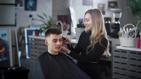 Barber Cuts a client in a trendy barber shop. Hairdresser woman blonde Stock Footage 236192436