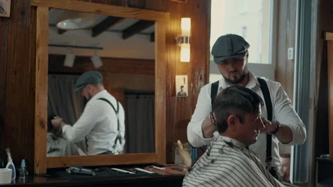 Barber cuts the client with a trimmer. Reflection in the mirror. Stock Footage 132285494