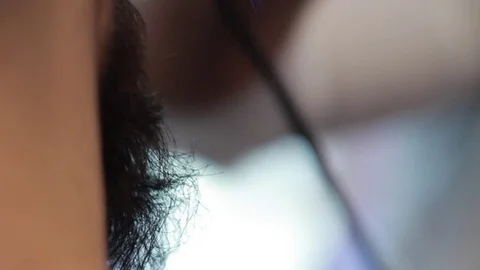 Barber cuts client’s beard with professional beard trimmer in barbershop Stock-Footage 73566093