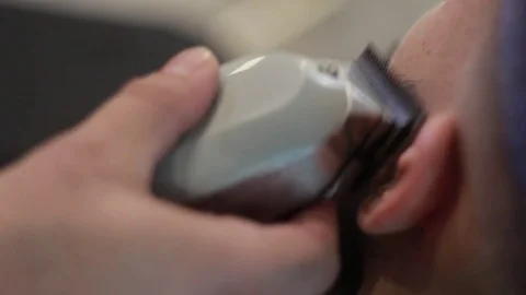 Barber cuts client’s beard with professional beard trimmer in barbershop Stock-Footage 73566104