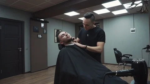 Barber cuts the customer's beard with a razor. Stock Footage 81531453