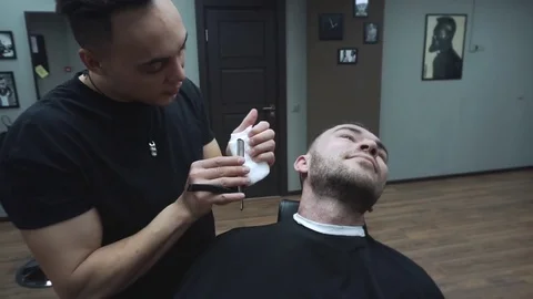 Barber cuts the customer's beard with a razor. Stock Footage 81532097