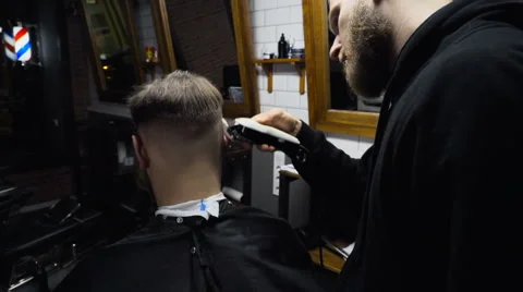 Barber cuts the hair of the client with clipper slow motion Video stock 60051385