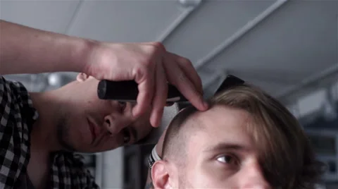 Barber cuts the hair of the client with clipper Stock Footage 62947735