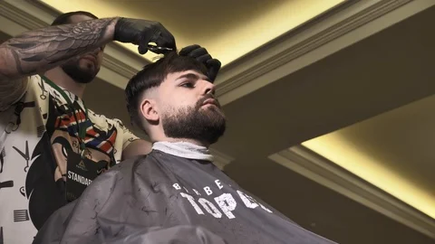 Barber cuts the hair of the client with scissors Видео 88716567