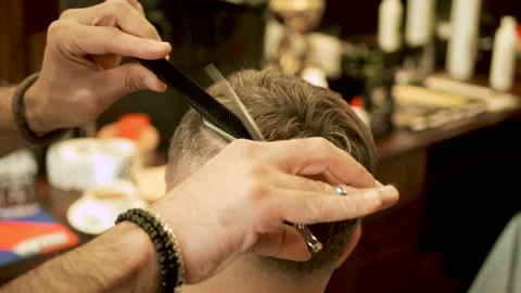 Barber cuts the hair of the client with scissors close-up Stock Footage 102205083