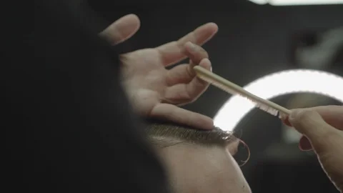 Barber cuts the hair of the client with scissors. Close up. Attractive male is Stock Footage 112605992