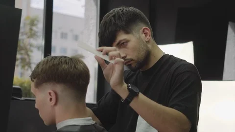 Barber cuts the hair of the client with scissors. Close up. Attractive male is Stock Footage 112606522