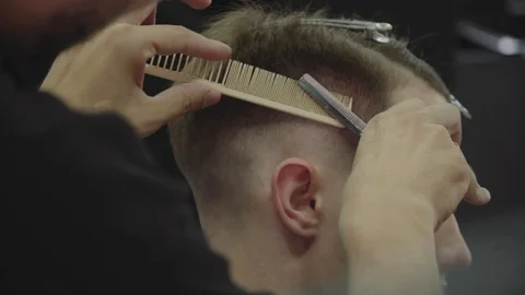 Barber cuts the hair of the client with scissors. Close up. Attractive male is Video stock 112606555