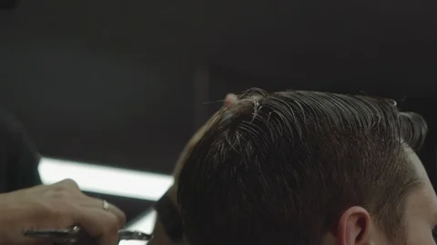 Barber cuts the hair of the client with scissors. Close up. Attractive male is Video stock 112830949