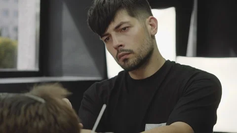 Barber cuts the hair of the client with scissors. Close up. Attractive male is Video stock 112831188