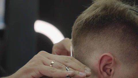 Barber cuts the hair of the client with scissors. Close up. Attractive male is Video stock 112831229