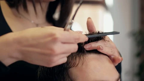 Barber cuts the hair of the client with scissors close-up. Frame. Barber combing Stock Footage 120265555