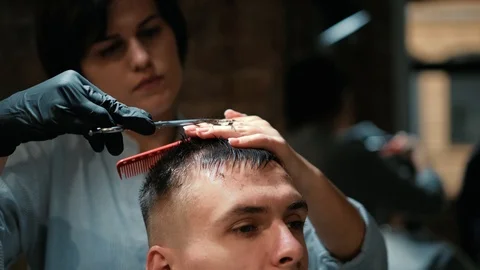 Barber cuts the hair of the client with scissors close-up. Frame. Barber combing Stock Footage 120266460