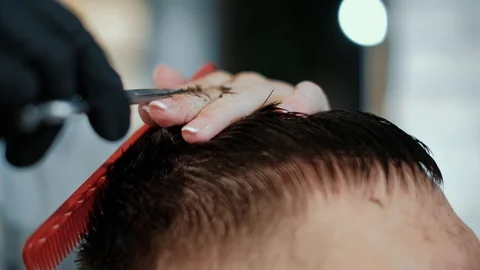 Barber cuts the hair of the client with scissors close-up. Frame. Barber combing Stock Footage 120266535