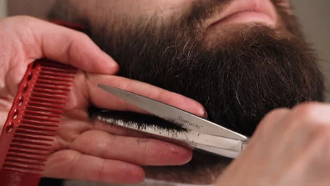Barber cuts a man's beard with scissors Stock Footage 157621562