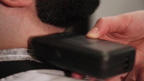 Barber cuts a man's beard with a typewriter in the salon Stock Footage 157621340