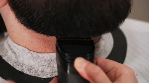 Barber cuts a man's beard with a typewriter in the salon Stock Footage 157621349
