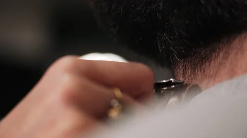 Barber cuts a man's beard with a typewriter in the salon Stock Footage 157621408