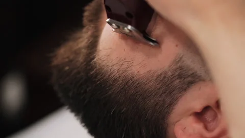 Barber cuts a man's beard with a typewriter in the salon Stock Footage 157621486