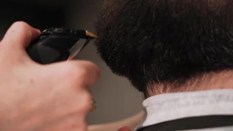 Barber cuts a man's beard with a typewriter in the salon Stock Footage 157621830