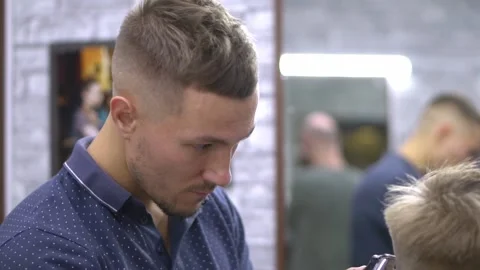 Barber cuts a young boy Vídeo Stock 149860425