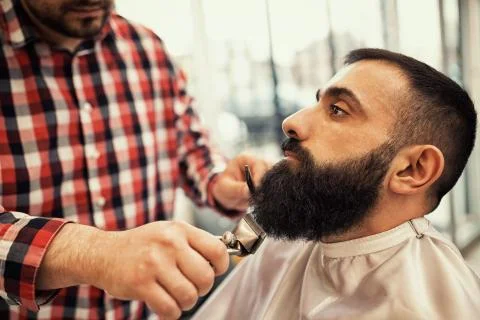 Barber cutting a beard with scissors, beard must be perfect Stock Photos